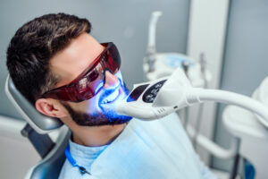 Man getting professional teeth whitening done at a dental office
