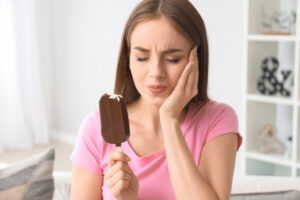 Women showing pain while holding a popsicle